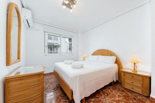 a white bedroom with a bed and a window at Sunrise Arts 2 in Torrevieja