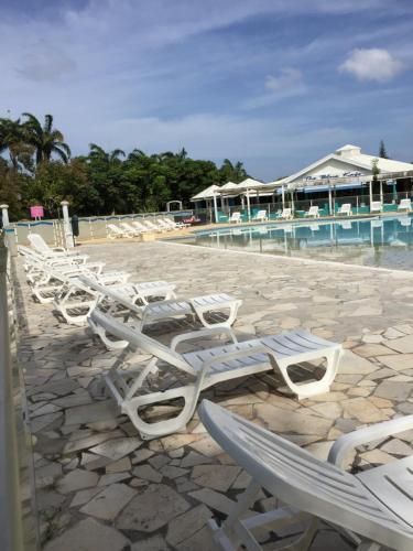 a row of chaise lounge chairs on a beach with a resort at Kazalou in Saint-François