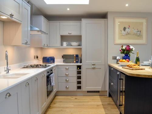 a kitchen with white cabinets and a counter top at Grange Loft - Uk31594 in Dundee