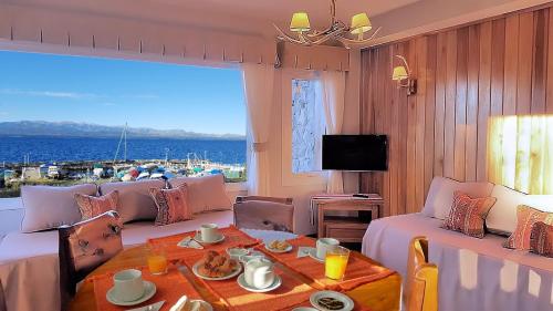 a room with a table and a view of the ocean at El Nautico Lodge Bariloche in San Carlos de Bariloche