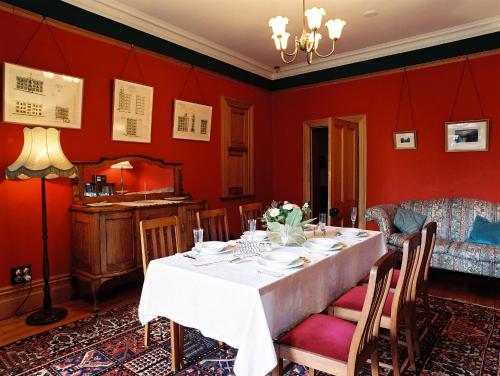 uma sala de jantar com paredes vermelhas e uma mesa em Braemar On Parliament St em Auckland