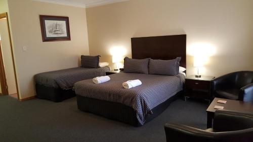 A bed or beds in a room at Gateway Motor Inn - Self Check-In