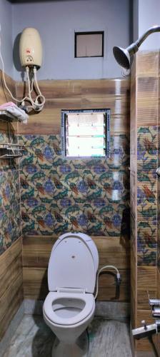 a bathroom with a toilet and a window at Howrah Homestay Nidhivan in Howrah
