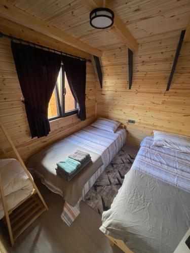 a room with two beds in a log cabin at Altınkum Bungalov in Dereköy