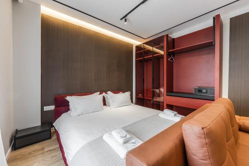 a bedroom with a large bed and a couch at Hotel Aquila D in Durrës