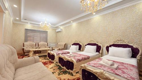 a bedroom with three beds and a chandelier and a chandelier at Private 3BR House 2 Min Walk to Registan in Samarkand