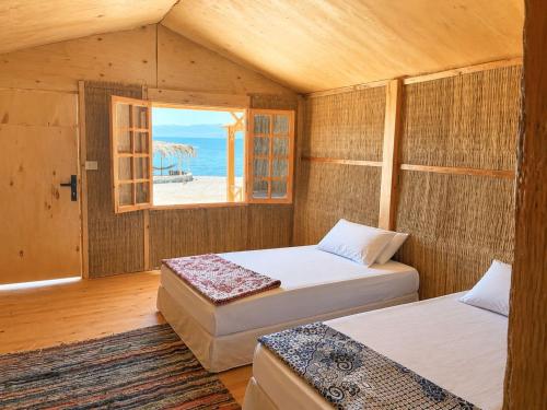 zwei Betten in einem Zimmer mit Meerblick in der Unterkunft Falak in Taba