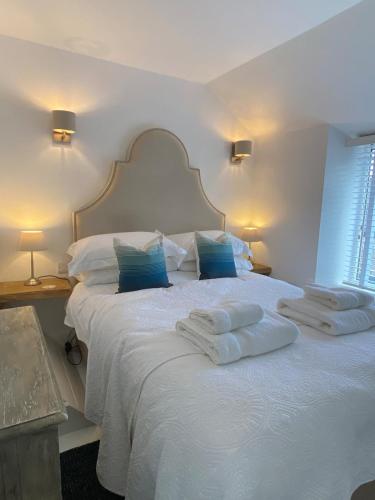 a bedroom with a white bed with two towels on it at Hidden Gem - Charmouth Dorset in Charmouth