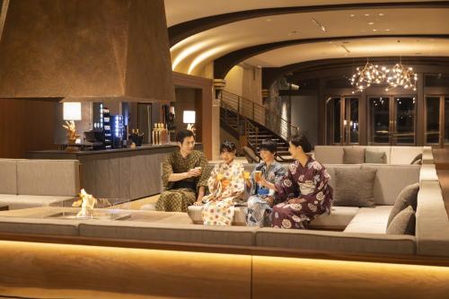 a group of people sitting on a couch in a building at Ooedo Onsen Monogatari Premium Enakyo in Ena