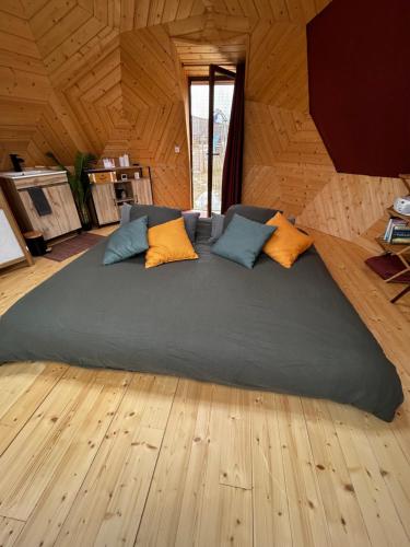 a large bed in a room with wooden floors at Dôme géodésique in Brie