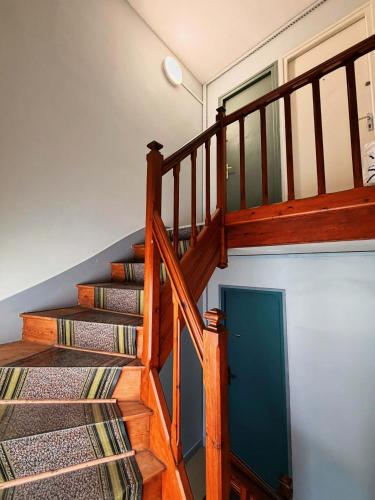 a wooden staircase with a green door in a house at Studio LS - Plage, falaise, Funiculaire, in Le Tréport