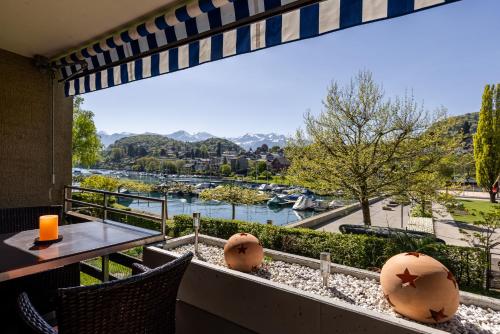 a balcony with a table and chairs and a view of a river at Buchtoase in Spiez