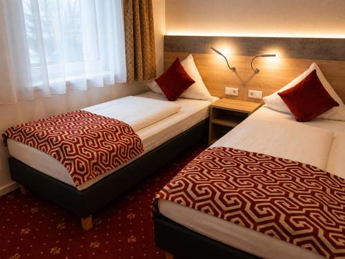 ein Hotelzimmer mit zwei Betten und einem Fenster in der Unterkunft Hotel Stadion Stadt in Hamburg