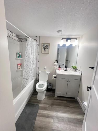 a bathroom with a white toilet and a sink at Purplecherry Haven in Regina