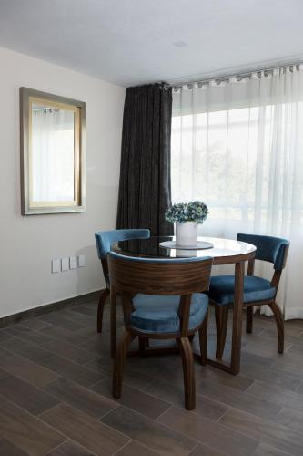 a dining room with a table and blue chairs at Suites Rio Elba in Mexico City