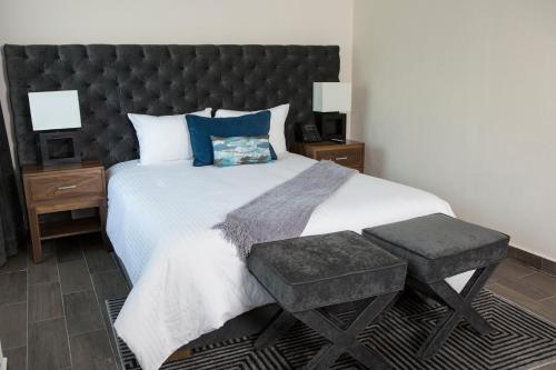 een slaapkamer met een groot bed met een zwart hoofdeinde bij Suites Rio Elba in Mexico-Stad