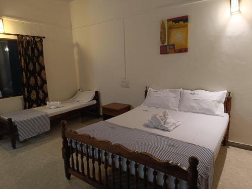 a bedroom with two beds and a window and a bed at Panchavadi Beach Resort in Varkala