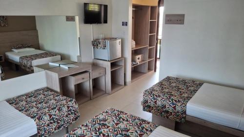 a small room with two beds and a tv at Hotel Giada in Sámara