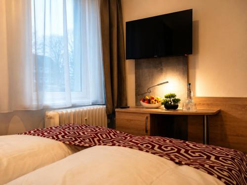 ein Hotelzimmer mit Bett und Flachbildfernseher in der Unterkunft Hotel Stadion Stadt in Hamburg