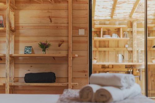 a room with wooden walls and a bed with towels at Soul Farm Algarve - Glamping & Farm Houses in Aljezur