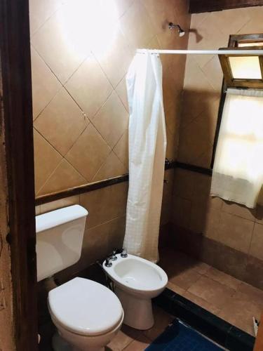 ein kleines Badezimmer mit Toilette und Waschbecken in der Unterkunft Hotel Jasy in Puerto Iguazú