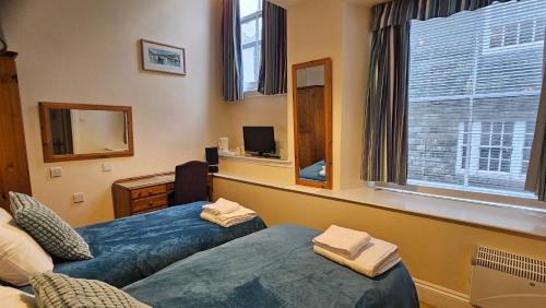 a bedroom with two twin beds and a window at The Ship Inn Looe in Looe
