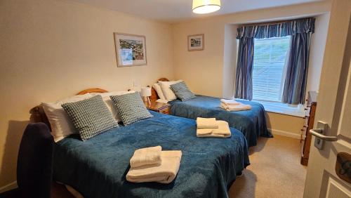 two beds in a room with towels on them at The Ship Inn Looe in Looe