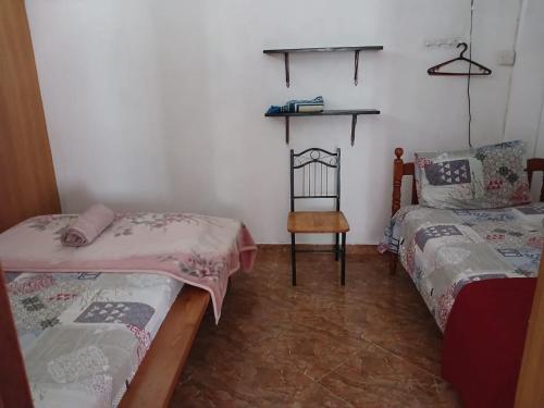 a room with two beds and a chair in it at Green Peak Stay in Port Louis