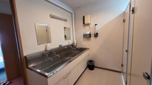 a bathroom with a sink and a mirror at Shimano Yado Rishirikuru in Rishiri