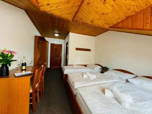 a hotel room with two beds and a desk and a table at Penzión U Tonky in Tomek