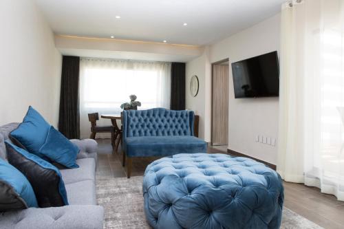 a living room with a blue couch and a table at Suites Rio Elba in Mexico City