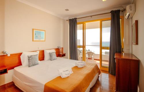 a bedroom with a bed with a view of the ocean at FLH Monte Gordo Balcony Flat in Monte Gordo