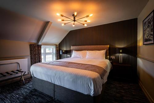 a bedroom with a large bed and a chandelier at The White Swan in Scotter