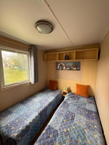 two beds in a small room with a window at Casa da Agueira AC1 in Pataias