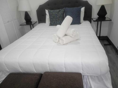 a bedroom with a white bed with towels on it at Downtown Studio at San Juan JL Guaynabo in San Juan