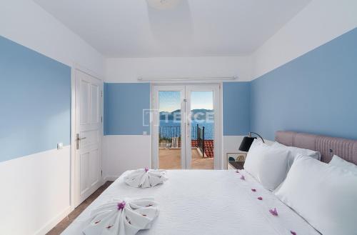 a bedroom with a white bed with a view of the ocean at TEKCE Villa Mae N3 in Yeniköy