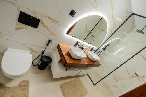 a bathroom with a toilet and a mirror at Sharksproperties Luxury 3BR Ocean View Apartment with Rooftop Pool 6 Guests in Mindelo