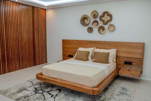 a bedroom with a bed with a wooden headboard at Sharksproperties Luxury 3BR Ocean View Apartment with Rooftop Pool 6 Guests in Mindelo