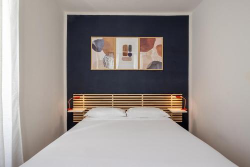 a bedroom with a white bed with two pillows at Bebyme - EPICENTRUM in La Spezia