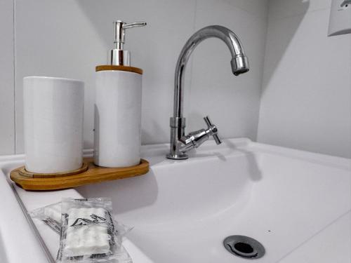 a sink with a faucet and two rolls of paper towels at Apto no coração de Brusque in Brusque