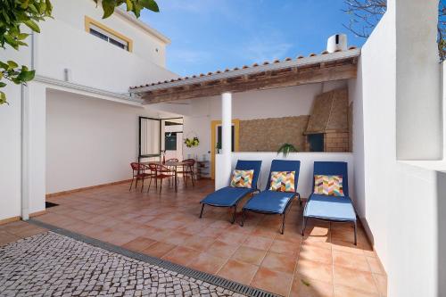 a patio with two blue chairs and a table at Modern Villa In Olhao in Quelfes