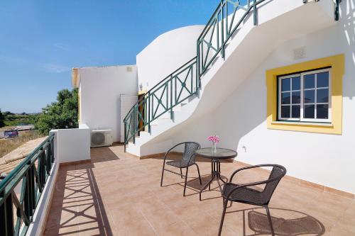 a balcony with a table and chairs on a house at Modern Villa In Olhao in Quelfes