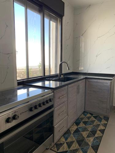 a kitchen with a sink and a large window at Olives Hill Farm in Al Kufayr