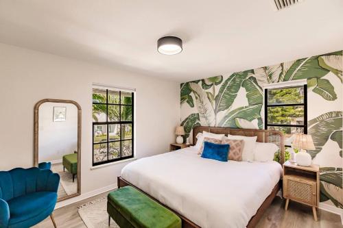 a bedroom with a large bed and a blue chair at Casa Marco - Heated Pool, Game Room, Mini Golf in Marco Island