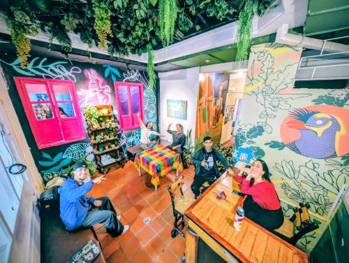 a group of people sitting at a bar in a room at Lienzo Hostal Popayán in Popayan