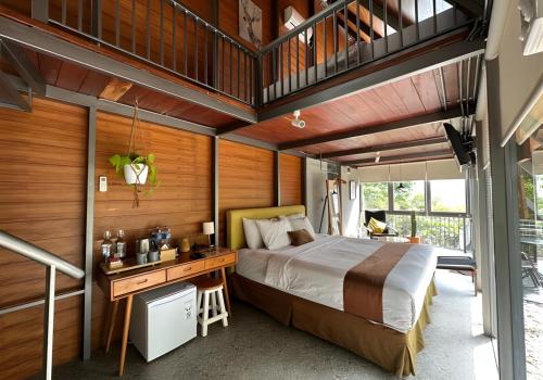 a bedroom with a king sized bed and a desk at villa tibra in Lembang