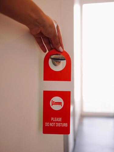 a person holding a do not disturb sign on a wall at Hotel Keli in Ksamil
