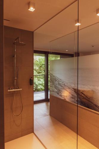 a bathroom with a shower and a glass wall at Huyze Fox - Boutique Stays in Bruges