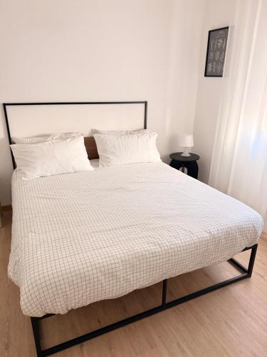 a bed with a white comforter and two pillows at Novelli Homes in Formigine