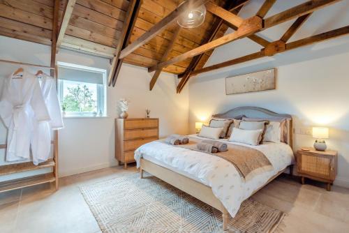 a bedroom with a large bed and wooden ceilings at 2 Bed in Blakeney oc-m42455 in Awre